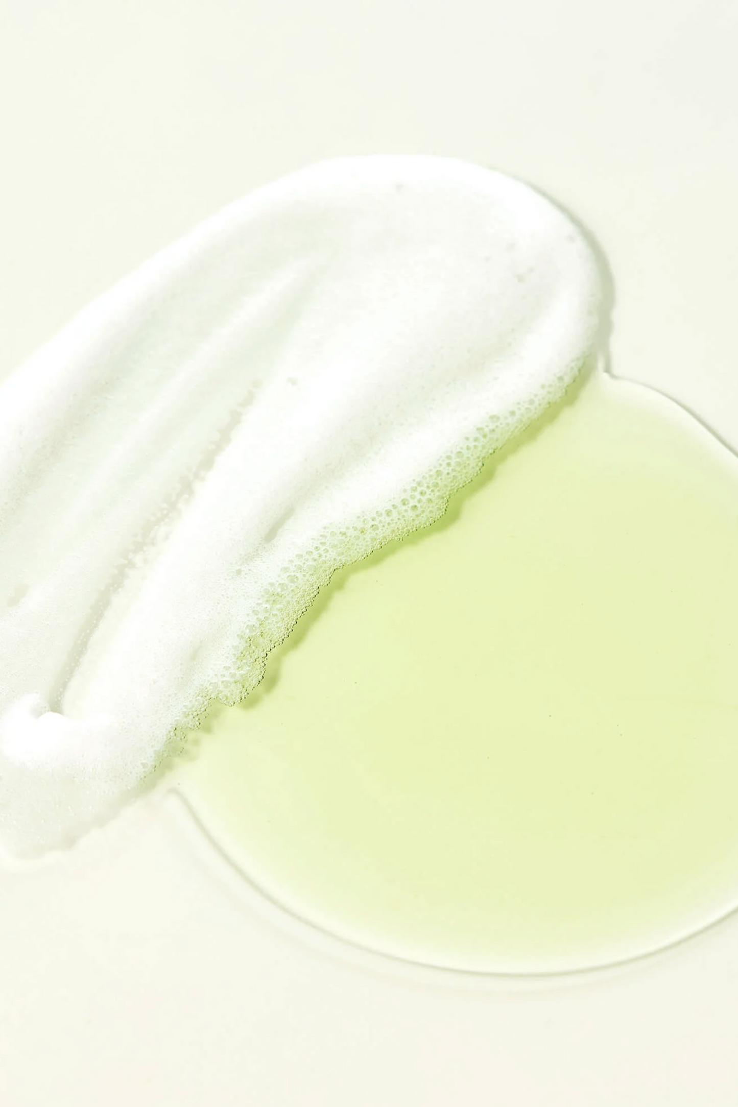 Green Clear Vegan Cleansing Oil To Foam texture shot of foaming bubbles and oil side by side.
