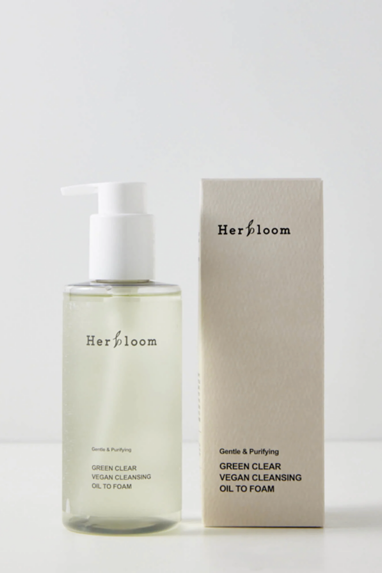 Herbloom Green Clear Vegan Cleansing Oil To Foam bottle next to its outer box, against a soft light grey background.