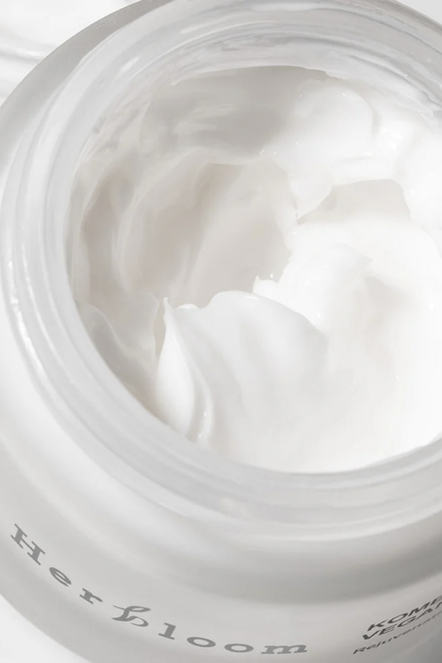 Aerial close up view of open Herbloom Kombucha Vegan Collagen Cream with the cream visible. Available for purchase at Sinless Skincare.