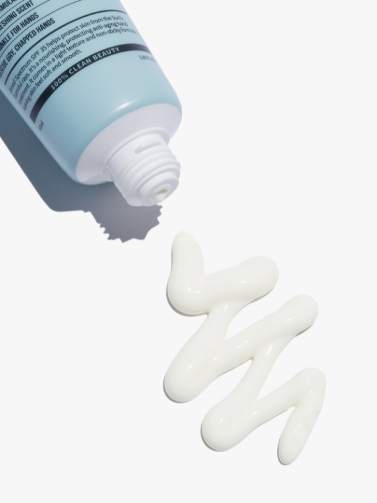 Top of Suntique's I'm 4 Seasons Hand Sun Cream on its side, uncapped, with a zigzag of cream on a white surface. Available at Sinless Skincare.