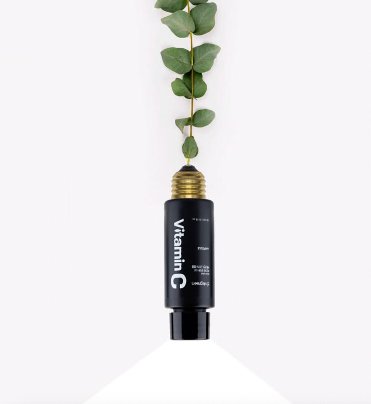 Open bottle of Vegreen's Intensive Vitamin C 20% Ampoule with green leaves sprouting from the top, on a white background. Available at Sinless Skincare.
