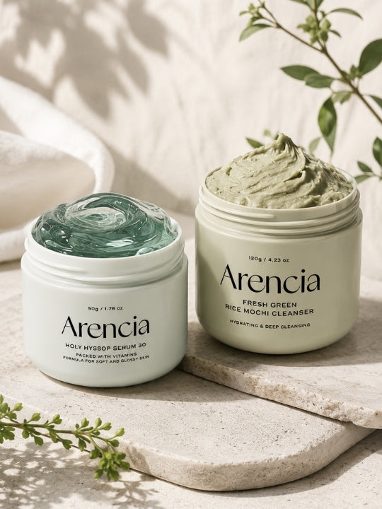 Two open jars of Arencia's Holy Hyssop Serum 30 and Fresh Green Rice Mochi Cleanser, with soft natural shadows and greenery in the background.