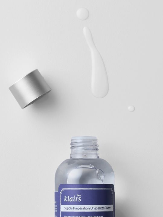Klairs bottle of Supple Preparation Toner Unscented with cap removed and droplet on a white background