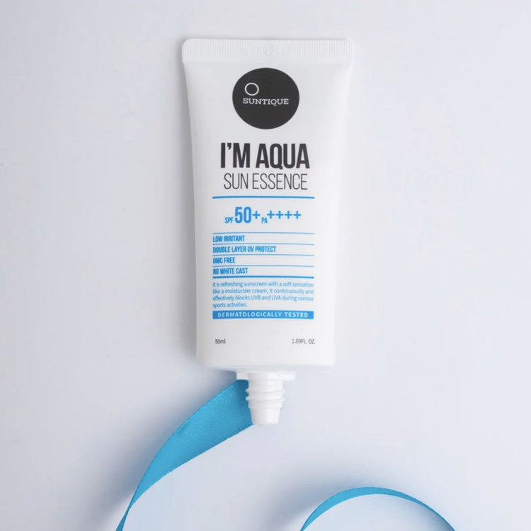 Tube of Suntique I'm Aqua Sun Essence sunscreen without a cap on a light grey background with blue ribbon