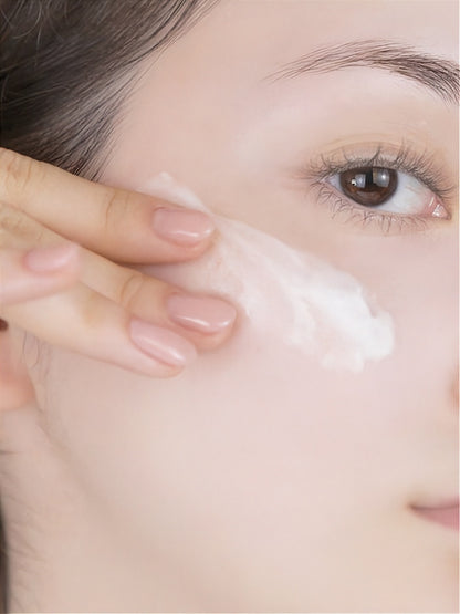 Close up of woman applying Vegreen 730 Daily Moisture Cream to her cheek.