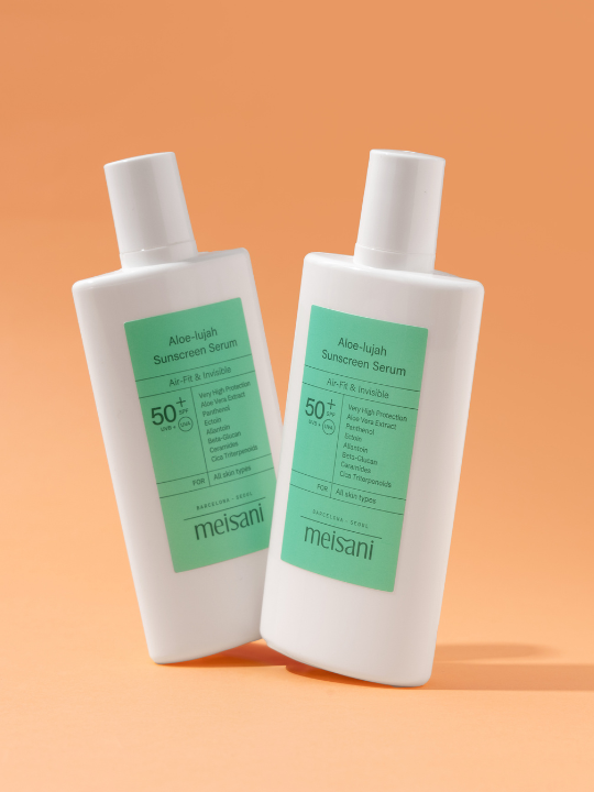 Two bottles of Meisani's Aloe-lujah Sunscreen Serum standing tilted against a light orange background.
