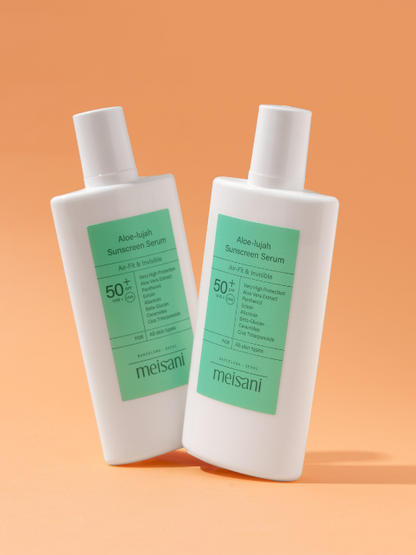 Two bottles of Meisani's Aloe-lujah Sunscreen Serum standing tilted against a light orange background.