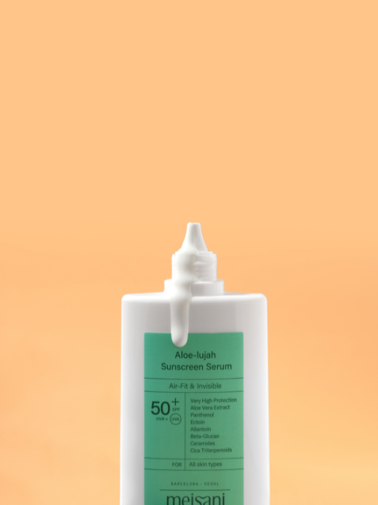 Meisani Aloe-lujah Sunscreen Serum uncapped with cream running down the front of the bottle. Light orange background.