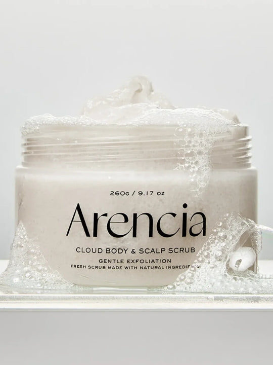 A jar of Arencia Cloud Body & Scalp Scrub, (White Tea & Neroli) with white foam and bubbles, shown on a clean white background.