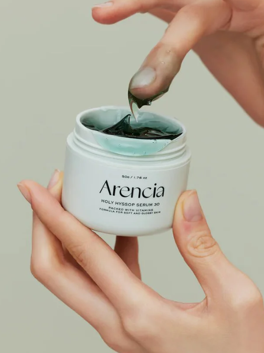 Person dipping finger in a jar of Arencia Holy Hyssop Serum 30. 
