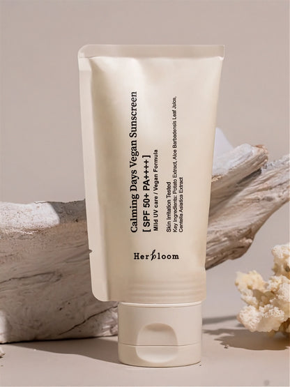 Herbloom Calming Days Vegan Sunscreen SPF 50+ tube on a neutral background with a white piece of natural wood.