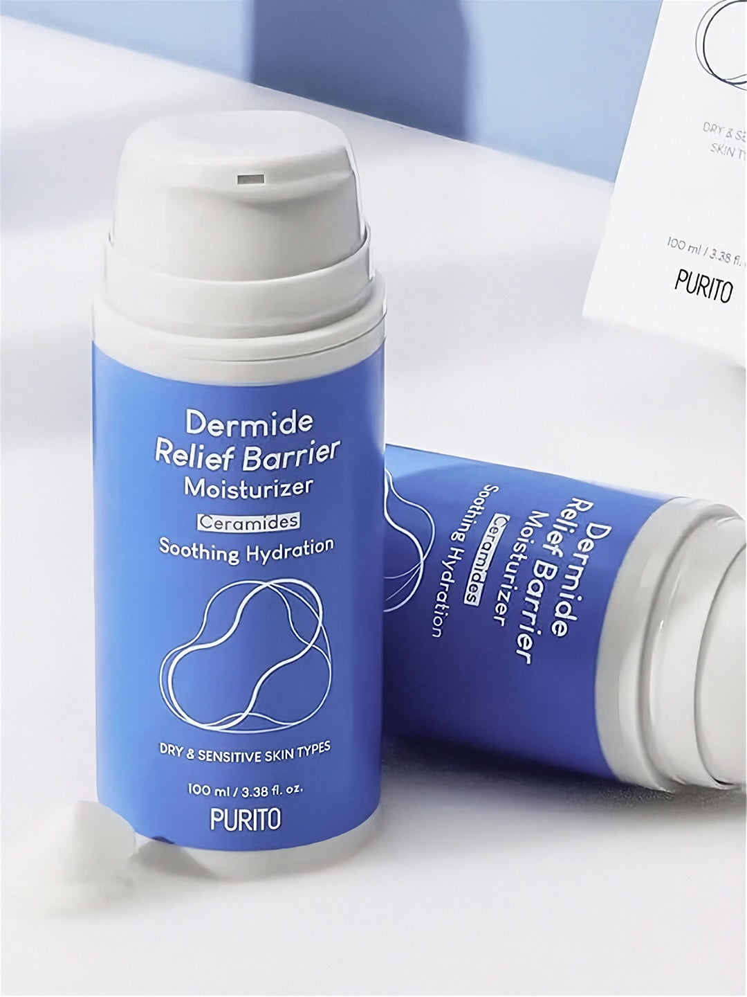 Two bottles of Purito Dermide Relief Barrier Moisturizer on a neutral background