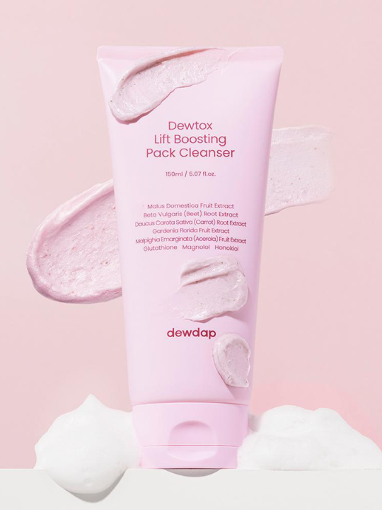 Pink tube of Dewdap Dewtox Lift Boosting Pack Cleanser on a pink background with swatches of pink mask and white cleansing foam. Available at Sinless Skincare.