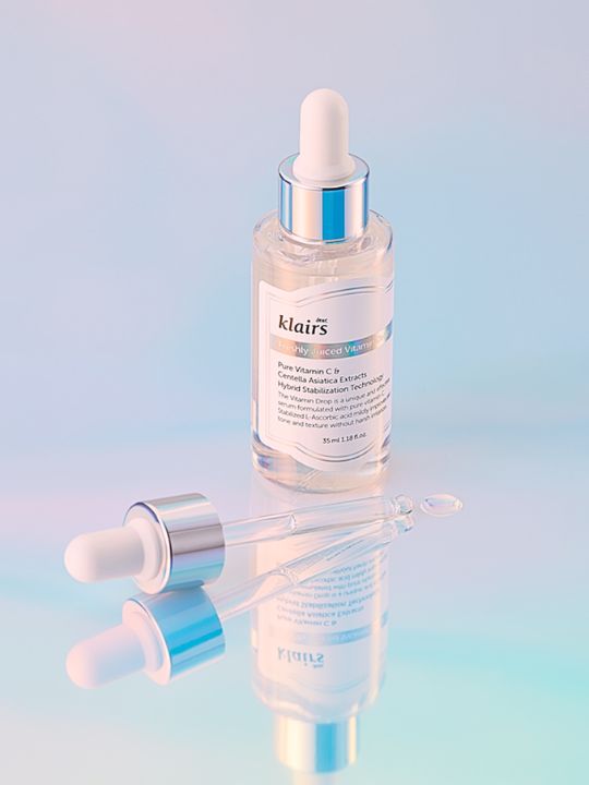 Klairs Freshly Juiced Vitamin Drop on a pastel blue mirrored surface