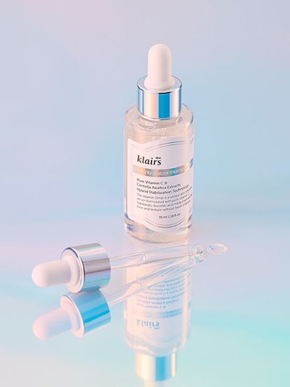 Klairs Freshly Juiced Vitamin Drop on a pastel blue mirrored surface