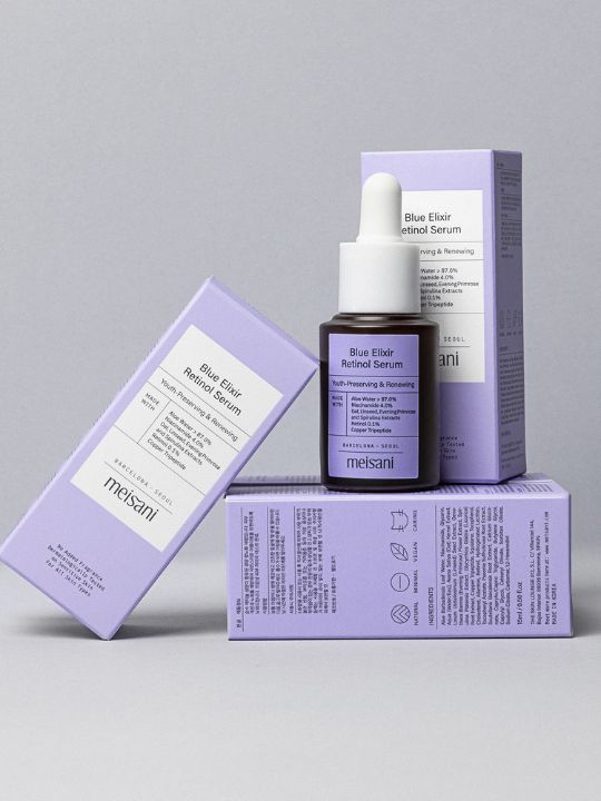 Meisani Blue Elixir Retinol Serum standing on its retail boxes - on a grey background