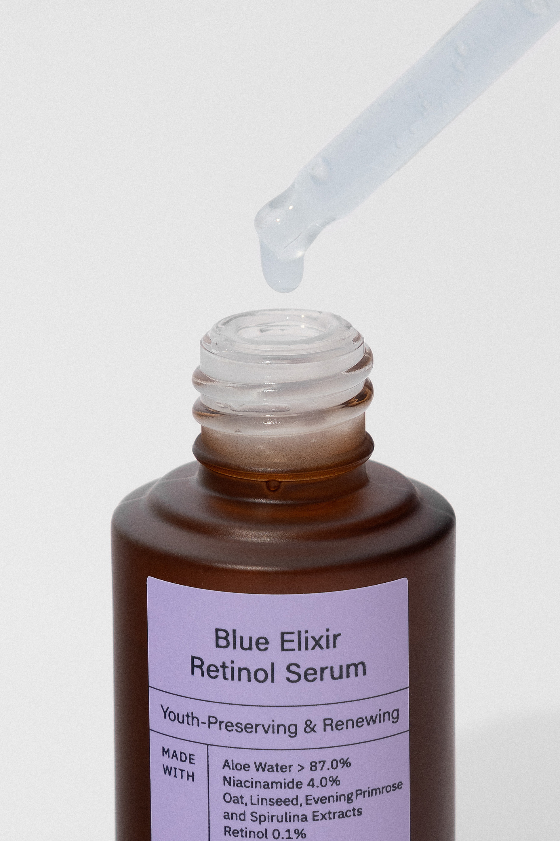 An open bottle of Meisani's Blue Elixir Retinol Serum with the dropper held above it, against a white background. Available for purchase at Sinless Skincare.