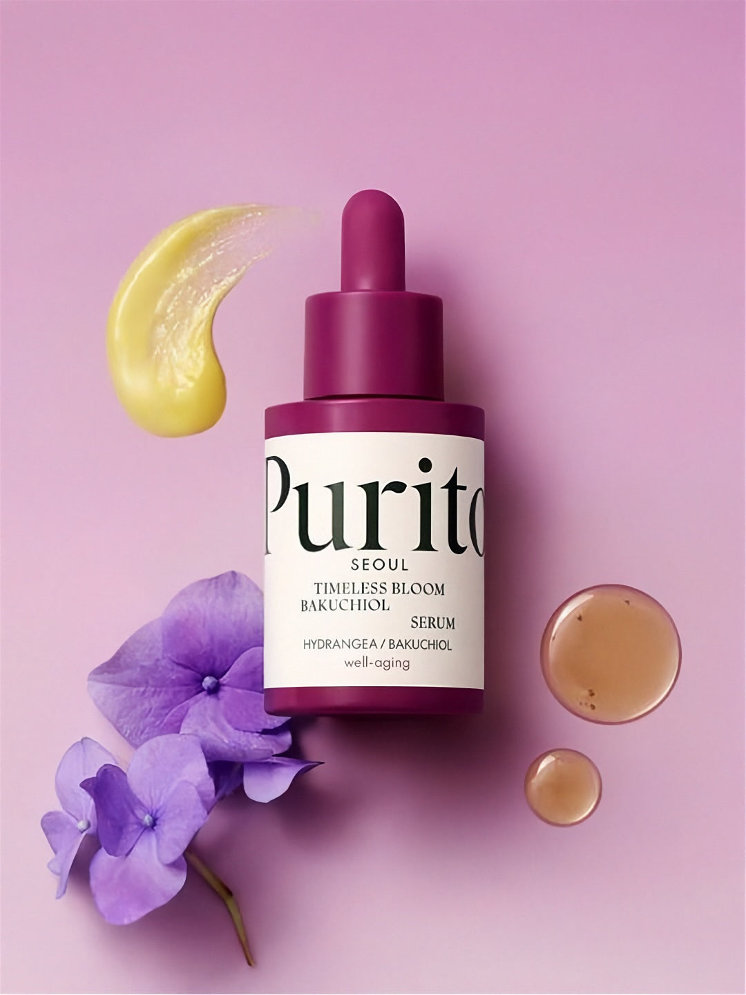 Bottle of Purito Timeless Bloom Backuchiol Serum on a light pink background with purple flowers and yellow cream swatch