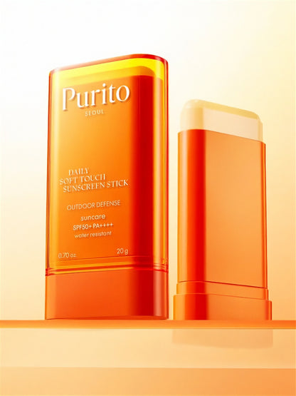 Two tubes of Purito Seoul Daily Soft Touch Sunscreen Stick with one cap off, on a light orange background