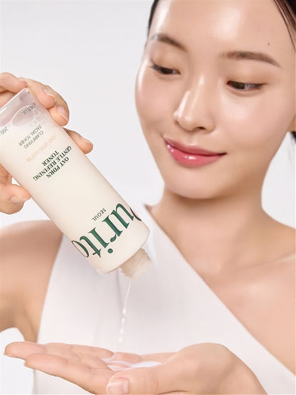 Woman pouring liquid from a bottle of Purito Oat PDRN Gentle Refining Toner onto her hand against a white background