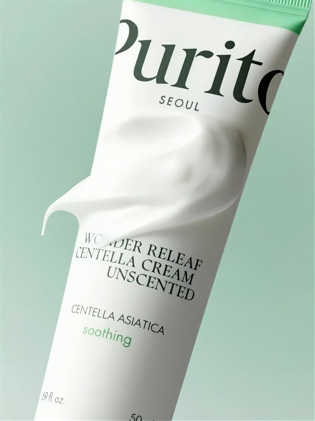 Tube of Purito Wonder Releaf Centella Unscented Cream with swatch of white cream covering its label, on a light green background