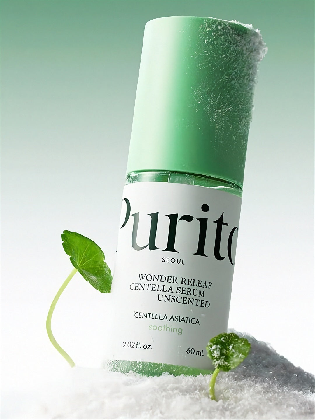 Purito Wonder Releaf Centella Serum bottle standing on white powder with green cap and cica leaves on a light green background