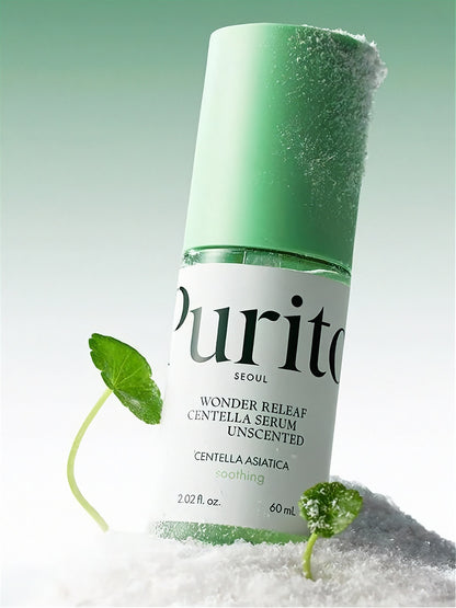 Purito Wonder Releaf Centella Serum bottle standing on white powder with green cap and cica leaves on a light green background
