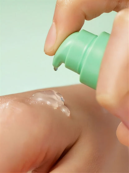 Hand applying Purito Wonder Releaf Centella Serum Unscented to other hand on a light green background