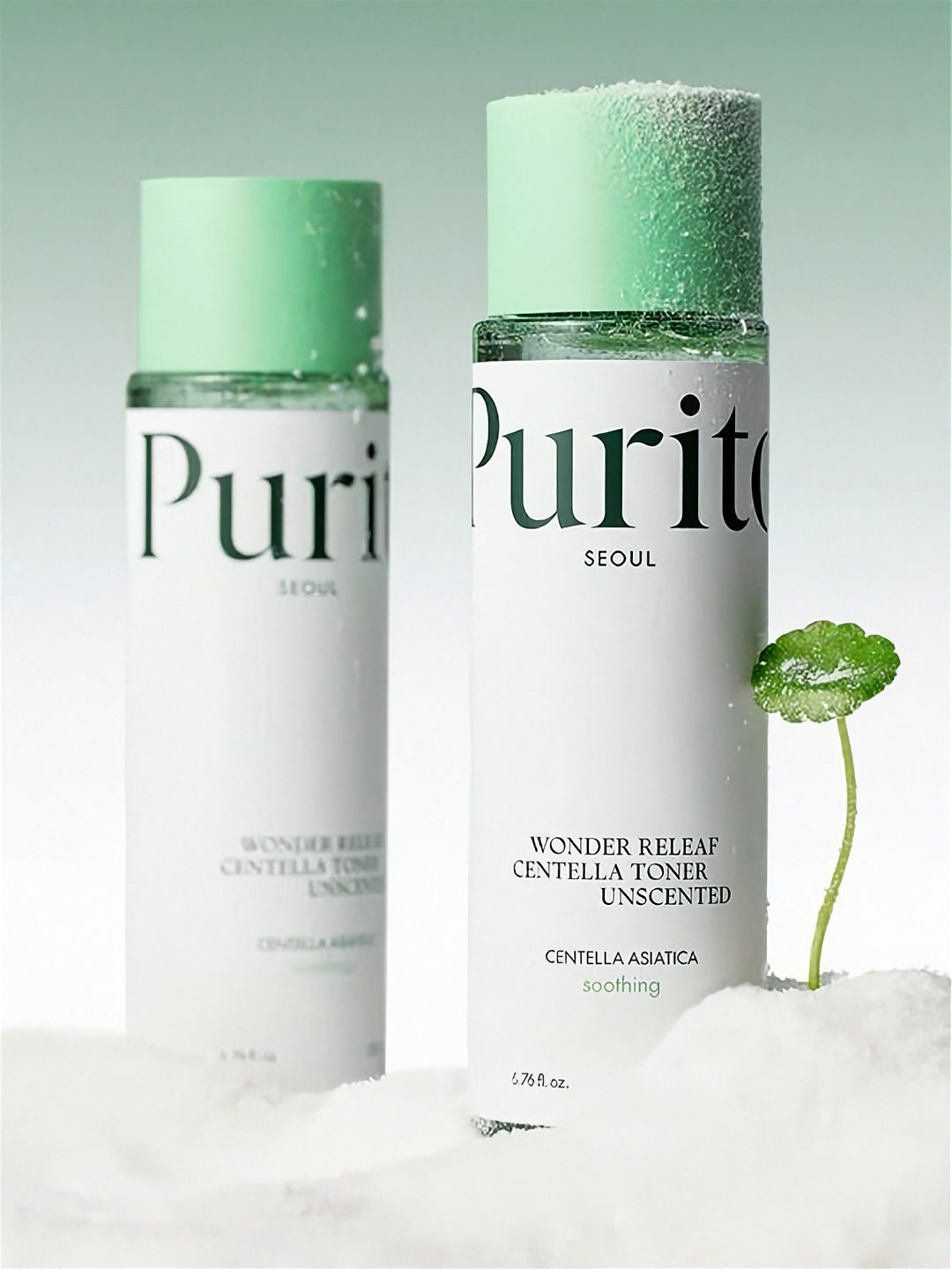 Two bottles of Purito Wonder Releaf Centella Toner Unscented standing on white powder with a green cica plant, against a light gradient green background