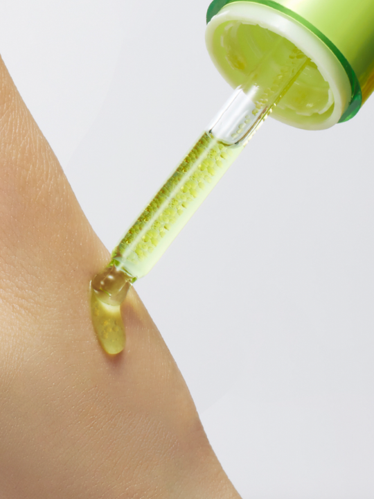 Bottle of Purito Azelaic Acid Kojic Tea Tree Serum with dropper on hand.