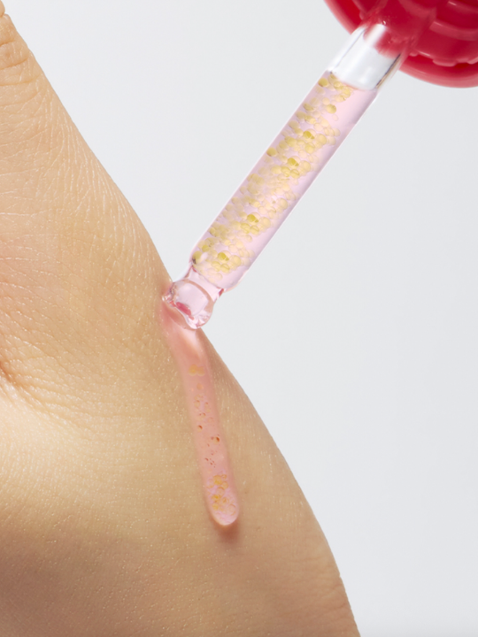 Purito TXA Niacinamide Retinal serum dropper and serum on hand.