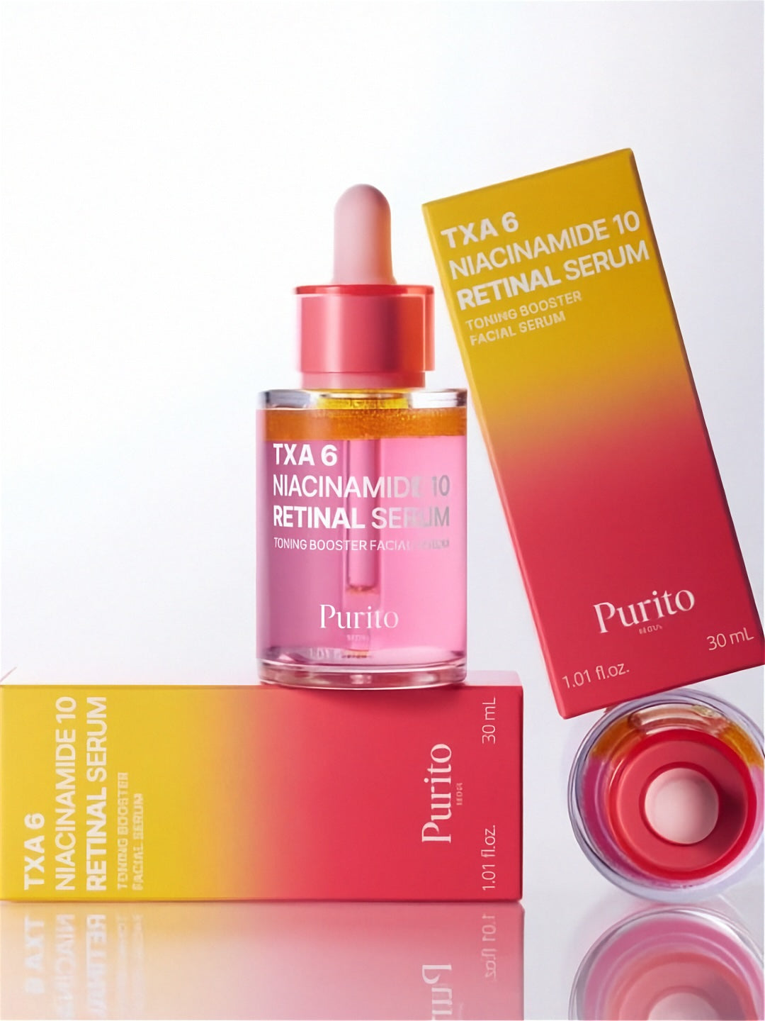 Bottle of Purito Seoul TXA 6 Niacinamide 10 Retinal Serum standing on and next to its retail boxes against a white background