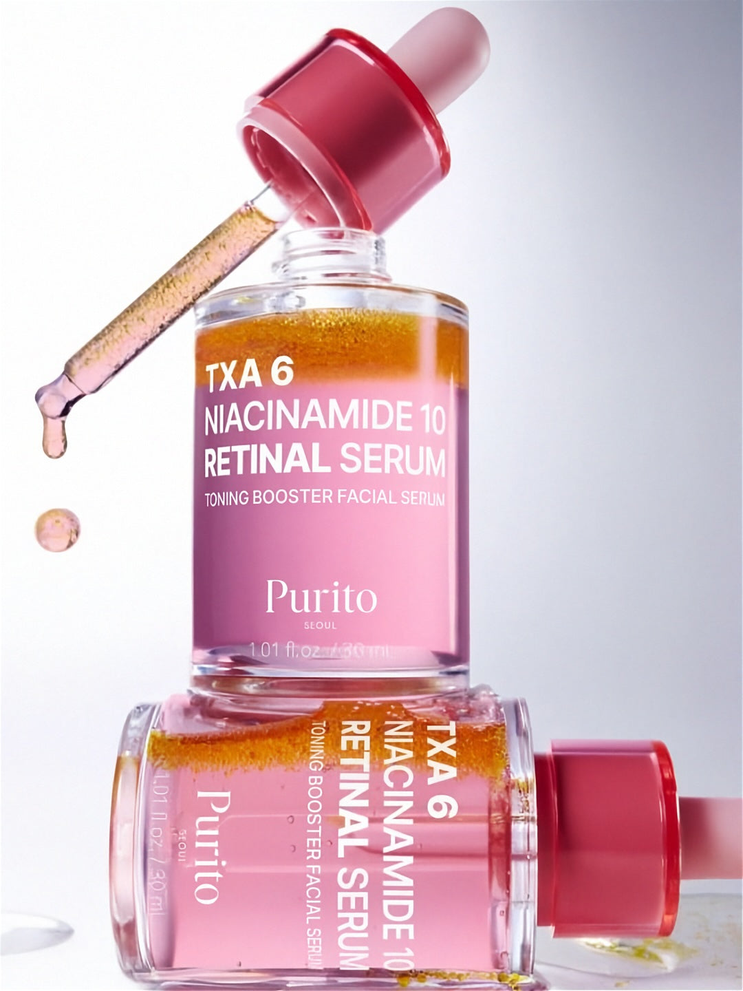 Bottle of Purito Seoul TXA 6 Niacinamide 10 Retinal Serum with its dropper out, standing on another serum bottle against a light grey background