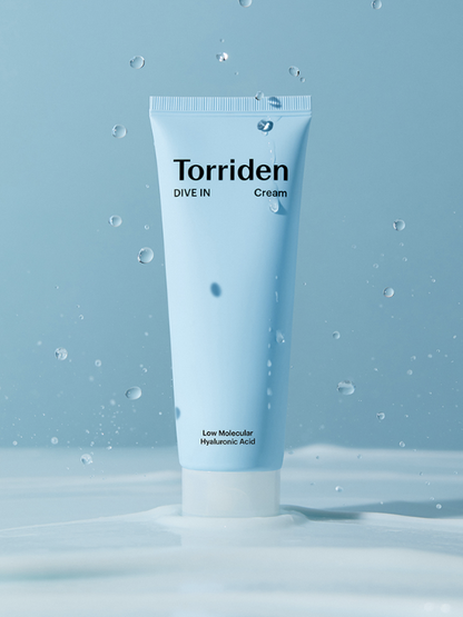Tube of Torriden's Dive In Hyaluronic Acid Cream against a blue background and drops of water falling down. Available at Sinless Skincare.