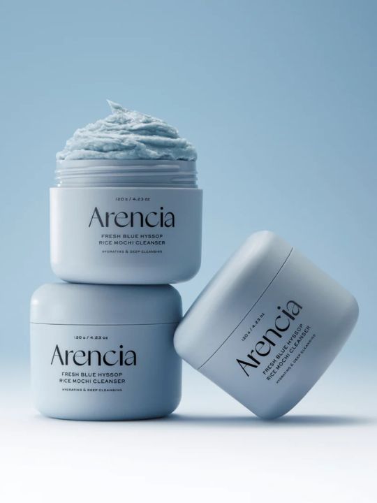 Three jars of Arencia Blue Hyssop Rice Mochi Cleanser on a blue background