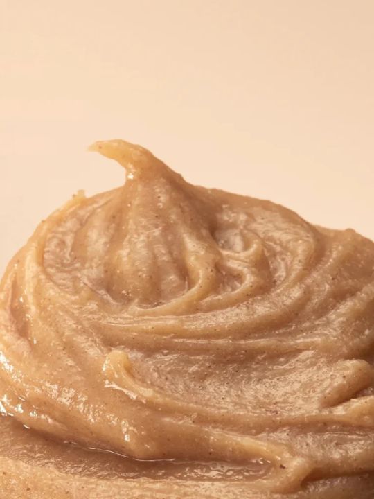 Close-up of a swirl of Arencia Calendula Rice Mochi Cleanser on a beige background