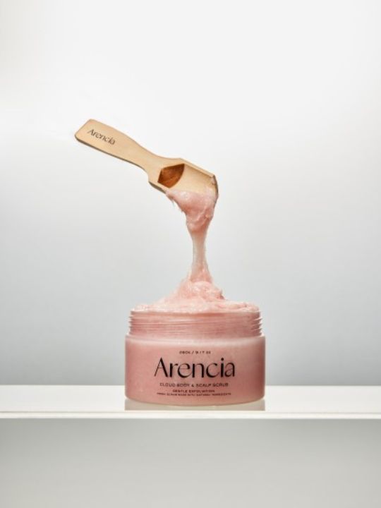 Open jar of Arencia Cloud Body & Scalp Scrub Pear & Lavender with a floating wooden spatula on a light grey background