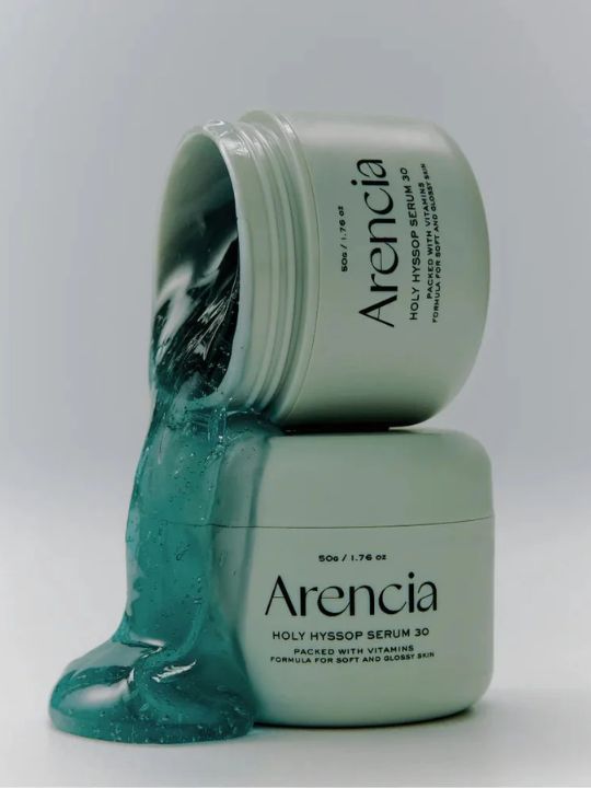 Two jars of Arencia Holy Hyssop Serum 30 with one open, showing the green serum.