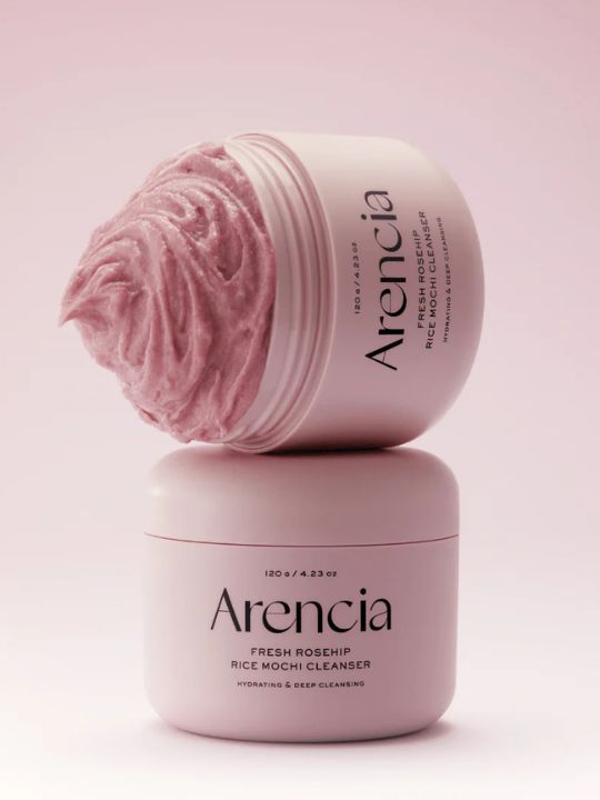 Two jars of Arencia Rosehip Rice Mochi Cleanser on a pink background
