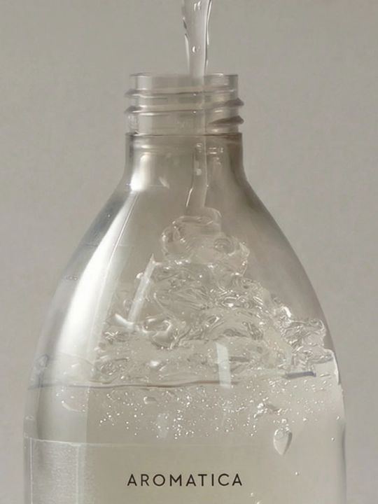 Bottle of Aromatica Organic Aloe Vera Gel being filled against a grey background