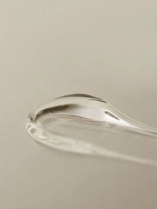 Close up texture swatch of Aromatica Organic Aloe Vera Gel on a light grey surface