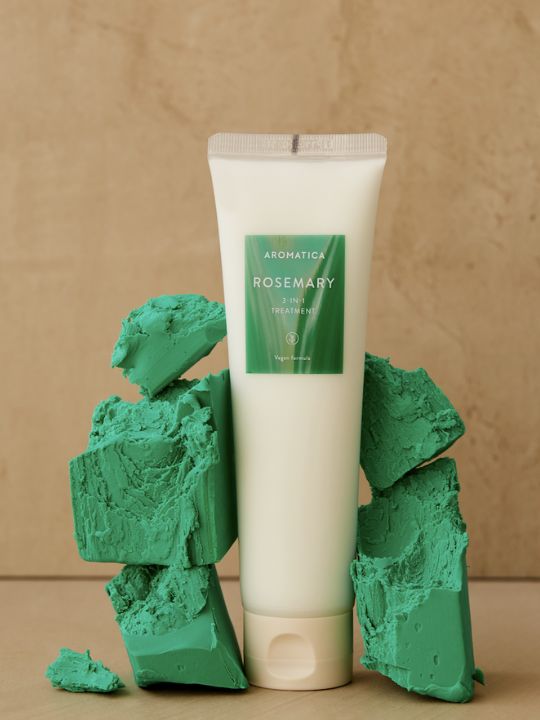 Tube of Aromatica Rosemary 3 in 1 Treatment with green decorative elements on a beige background