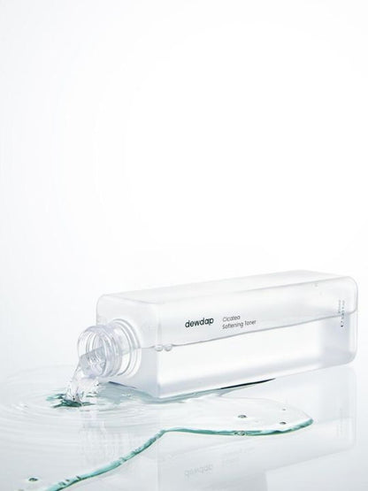 Bottle of Dewdap Cicatea Softening Toner lying open on its side with liquid pouring out, on a white background