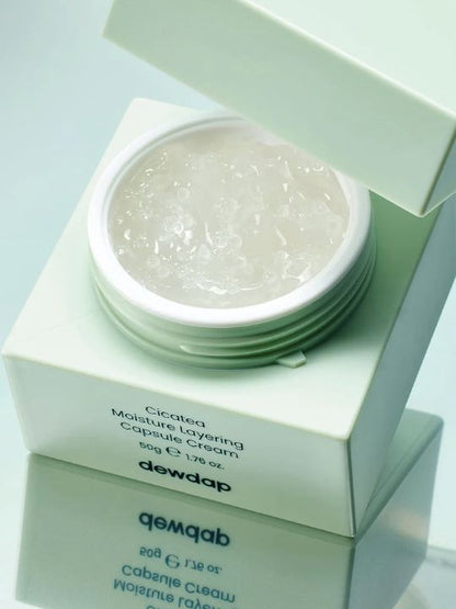 Open jar of Dewdap Moisture Layering Capsule Cream on a reflective surface