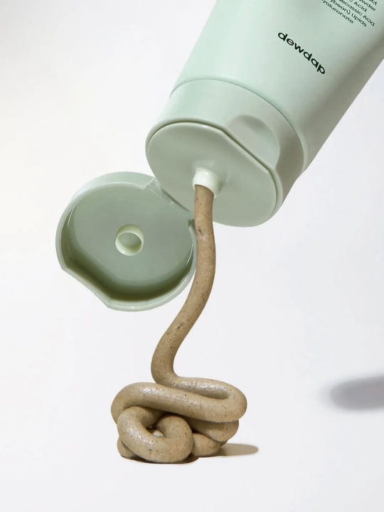 Tube of Dewdap Cicatea Pore & Sebum Pack Cleanser with a stream of cream flowing out on a white background.