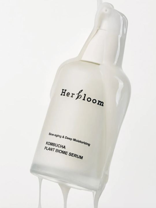 White cream running down a bottle of Herbloom Kombucha Plant Biome Serum on a white background