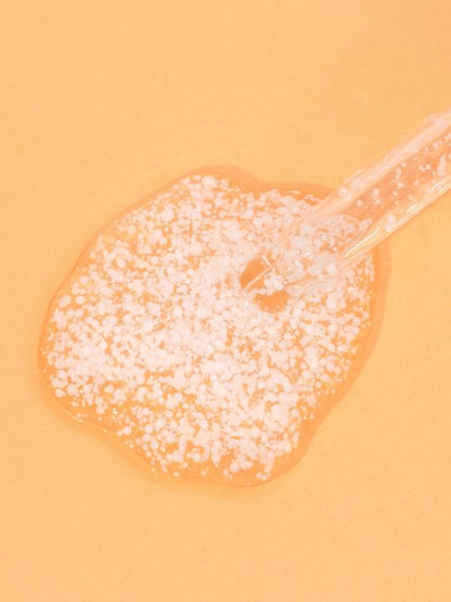 Meisani Glow Drops Vitamin C Serum dropper with close up texture on a orange background