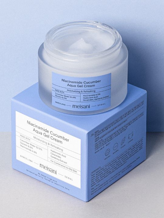 Open jar of Meisani Niacinamide Cucumber Aqua Gel Cream sitting on its retail box against a light blue background