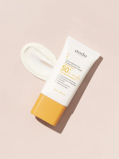 Ondo Beauty Ceramides & Cica Protective Sun Cream on a peach background with a swatch of cream