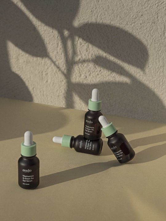 Four dropper bottles of Ondo Beauty Niacinamide & Green Tea Eye Serum on a neutral background with shadows